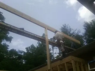 Carpenter setting a ridge beam over a new addition frame — Ice Dam Removal by Roofing Brothers in Pollocksville