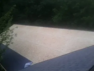 New OSB roof sheathing installed beside an existing shingle roof in Pollocksville