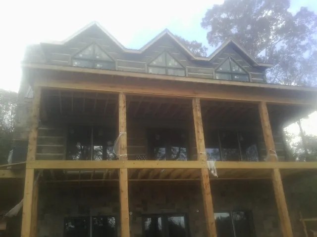 Dormers and porch framing on a large log home under construction — Roof Coating work by our crew in Pollocksville