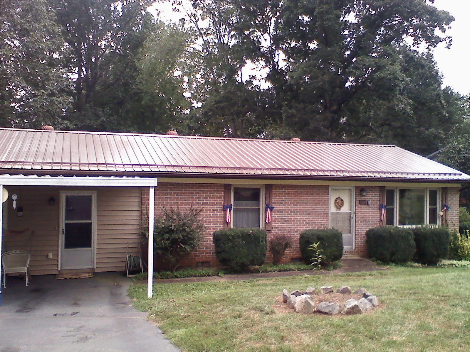 Bronze metal roof and carport on a brick ranch home — Roof Repair work by our crew in Pollocksville